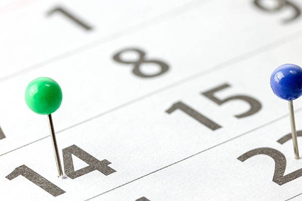 Monatskalender Ausschnitt mit zwei Stecknadeln.